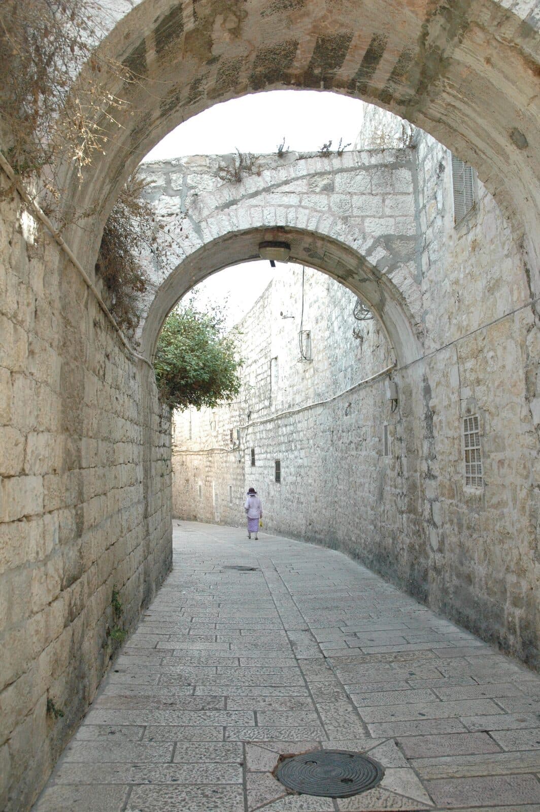 A quiet stone alley beneath an arch in Jerusalem’s Old City